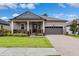 Charming single-story home with a covered front porch, manicured lawn, and two-car garage at 5005 Southern Valley Loop, Brooksville, FL 34601