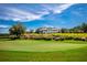 Beautiful view of the golf course with expansive green and grand clubhouse on a scenic, partly cloudy day at 5005 Southern Valley Loop, Brooksville, FL 34601