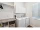 Efficient laundry room featuring cabinetry, counter space, and modern washer and dryer at 5005 Southern Valley Loop, Brooksville, FL 34601