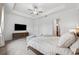 Bright main bedroom features a tray ceiling, sleek ceiling fan, and a tv with console at 5005 Southern Valley Loop, Brooksville, FL 34601
