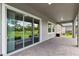 Covered patio overlooking a serene green lawn with mature trees and manicured landscaping at 5005 Southern Valley Loop, Brooksville, FL 34601
