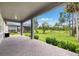 Covered patio overlooks a serene green lawn with mature trees and manicured landscaping at 5005 Southern Valley Loop, Brooksville, FL 34601