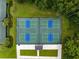 Overhead view of four pickleball courts nestled amidst verdant landscaping and mature trees at 5005 Southern Valley Loop, Brooksville, FL 34601