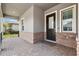 Welcoming front porch with brick accents and a stylish paver floor leading to the front door at 5005 Southern Valley Loop, Brooksville, FL 34601