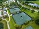 Aerial view of four beautifully maintained tennis courts within lush landscaping and nearby walking trail at 5005 Southern Valley Loop, Brooksville, FL 34601