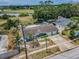 Charming blue home with lush landscaping and water views in the distance, featuring a lovely backyard at 5132 Flora Ave, Holiday, FL 34690