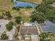 Aerial shot featuring the property, adjacent land, and a tranquil lake at 5132 Flora Ave, Holiday, FL 34690