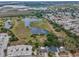 Aerial view showcasing the land, nearby lake, and neighboring houses at 5132 Flora Ave, Holiday, FL 34690
