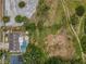 Aerial view of the property showing the pool, backyard, and nearby land at 5132 Flora Ave, Holiday, FL 34690