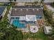 Aerial view of the property shows the pool, fire pit, shed, and landscaping at 5132 Flora Ave, Holiday, FL 34690