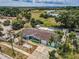 Aerial view of charming blue home, showcasing nearby lake views and lush surroundings at 5132 Flora Ave, Holiday, FL 34690
