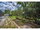 Serene backyard featuring decorative landscaping, mature trees, and a convenient storage shed at 5132 Flora Ave, Holiday, FL 34690
