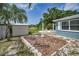 A backyard view showcasing a shed, landscaping, and a patio with seating at 5132 Flora Ave, Holiday, FL 34690