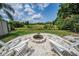 Backyard with Adirondack chairs surrounding the fire pit at 5132 Flora Ave, Holiday, FL 34690