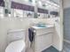 Well-lit bathroom with a blue sink, tiled walls, and ample storage space at 5132 Flora Ave, Holiday, FL 34690