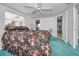 Spacious bedroom featuring a floral bedspread, ceiling fan, and tile flooring at 5132 Flora Ave, Holiday, FL 34690