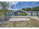 Charming single-story home with mature landscaping, manicured flowerbeds, and an attached two-car garage at 5132 Flora Ave, Holiday, FL 34690