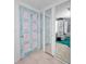 Unique hallway featuring decorative doors, mirrored walls, and tiled flooring at 5132 Flora Ave, Holiday, FL 34690