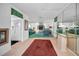 Open-concept hallway with view into living area and kitchen; red rug and tile flooring at 5132 Flora Ave, Holiday, FL 34690