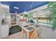 Bright kitchen with blue ceiling, white cabinets, and breakfast table overlooking the pool at 5132 Flora Ave, Holiday, FL 34690