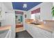 Bright kitchen features white cabinets, neutral counters, and a blue painted ceiling at 5132 Flora Ave, Holiday, FL 34690