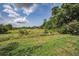 Picturesque vacant land with lush grass and a beautiful sky for development at 5132 Flora Ave, Holiday, FL 34690