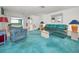 Inviting living room with vibrant turquoise carpet, comfortable seating, and ambient lighting at 5132 Flora Ave, Holiday, FL 34690