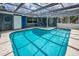 Enclosed pool offering a serene escape with outdoor seating and lush surroundings at 5132 Flora Ave, Holiday, FL 34690