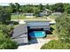 Aerial view of backyard with pool and deck, surrounded by lush greenery and privacy fence at 6158 Sumter Dr, Brooksville, FL 34602