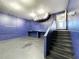 Unfinished basement with concrete floor and blue walls and stairs leading up to door at 6158 Sumter Dr, Brooksville, FL 34602