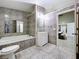Full bathroom showcasing a tub, vanity, and a uniquely tiled floor and walls at 6158 Sumter Dr, Brooksville, FL 34602
