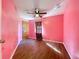 Bedroom featuring pink walls, wood floors, and a ceiling fan at 6158 Sumter Dr, Brooksville, FL 34602