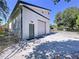 Exterior shot of detached garage featuring a roll-up door, side door, and chain link fence at 6158 Sumter Dr, Brooksville, FL 34602