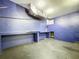 Garage interior featuring high ceilings, exposed ductwork, blue walls, and a concrete floor at 6158 Sumter Dr, Brooksville, FL 34602
