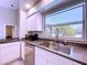 Well-lit kitchen with a large window over the sink and modern stainless steel dishwasher at 6158 Sumter Dr, Brooksville, FL 34602