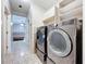 Convenient laundry room with modern washer and dryer set, tile flooring, and functional storage cabinets at 6158 Sumter Dr, Brooksville, FL 34602