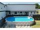 Backyard showcases an above ground pool surrounded by a wood deck and a spacious outdoor patio area at 6158 Sumter Dr, Brooksville, FL 34602