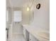 Bright bathroom featuring double sinks, white cabinets, marble countertop and a neutral color palette at 6231 Westport Dr, Port Richey, FL 34668