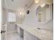 Bright bathroom featuring double sinks, white cabinets, marble countertop and a neutral color palette at 6231 Westport Dr, Port Richey, FL 34668