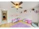 Bright bedroom featuring hardwood floors, a playful decor, and a ceiling fan at 6231 Westport Dr, Port Richey, FL 34668