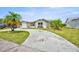 Charming single-story home featuring tropical landscaping and a concrete driveway at 6231 Westport Dr, Port Richey, FL 34668