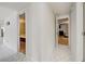 Hallway features white geometric tile flooring, light walls, and doorways to bedrooms at 6231 Westport Dr, Port Richey, FL 34668