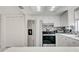View of a kitchen with stainless steel appliances, white cabinetry, and backsplash at 6231 Westport Dr, Port Richey, FL 34668