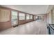 The light-filled sunroom features tile flooring, multiple windows, and access to the outdoors at 6231 Westport Dr, Port Richey, FL 34668