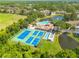Aerial view showcases tennis courts, shuffleboard, pool, ponds, and clubhouse amidst lush landscaping at 6508 Tina Dr # 14, New Port Richey, FL 34653