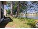 Scenic backyard overlooking a tranquil lake with mature trees, lush grass, and a peaceful water fountain at 6508 Tina Dr # 14, New Port Richey, FL 34653