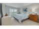 Bright bedroom featuring carpet, a large window, a queen-sized bed with blue and white bedding at 6508 Tina Dr # 14, New Port Richey, FL 34653