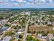 An aerial view of a home in a suburban neighborhood with well-maintained lawns and surrounding trees at 6823 Oak Hill Dr, New Port Richey, FL 34653