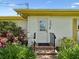 Back door entry with brick steps and a black metal railing, surrounded by lush landscaping at 6823 Oak Hill Dr, New Port Richey, FL 34653
