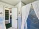 Retro bathroom featuring patterned wallpaper, a colorful tiled shower, and a peek into a storage area at 6823 Oak Hill Dr, New Port Richey, FL 34653